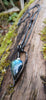 Labradorite bud and oxidised sterling silver pendant on a thick silver chain sitting on a mossy log, glinting blue in the sunlight.