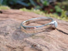 Silver and Amazonite stacking ring Sitting on a mossy Woodland log in the sunlight.
