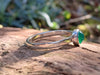 Silver and Green agate stacking ring Sitting on a mossy Woodland log in the sunlight.
