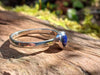 Sterling silver and Lapis Lazuli stacking ring. Sitting on a mossy log in the sunshine.