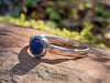 Sterling silver and Lapis Lazuli stacking ring. Sitting on a mossy log in the sunshine.