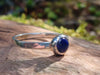 Sterling silver and Lapis Lazuli stacking ring. Sitting on a mossy log in the sunshine.