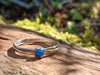 Sterling silver and Turquoise  stacking ring. Sitting on a mossy log in the sunshine.