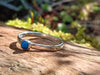 Sterling silver and Turquoise  stacking ring. Sitting on a mossy log in the sunshine.