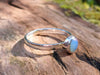 Sterling silver and Opalite stacking ring. Sitting on a mossy log in the sunshine.