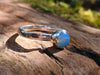 Sterling silver and Opalite stacking ring. Sitting on a mossy log in the sunshine.