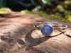 Sterling silver and Opalite stacking ring. Sitting on a mossy log in the sunshine.