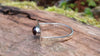 Sterling silver and garnet flat topped ring sitting on a log in the forest.