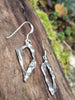 Sterling silver femscape earrings on a mossy log.