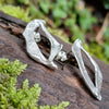 Sterling silver Femscape earrings sitting on a mossy log.