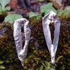 Sterling silver Femscape earrings sitting on a mossy rock.