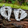 Sterling silver Femscape earrings sitting on a mossy log.