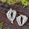 Sterling silver Femscape earrings sitting on a mossy log.