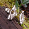 Sterling silver Femscape earrings sitting on a mossy log.