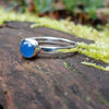 Bright Blue Onyx stacking ring sitting on a mossy log in the sun