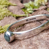 sterling silver 4mm dark Moss agate stacking ring on a mossy log