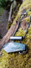 Oxidised silver pendant with coffin shaped  moss agate stone on a chunky chain. Sitting on a mossy log 