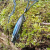 Oxidised silver pendant with a long oval Labradorite stone and a chunky chain sitting on a mossy log.