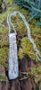 Long Straight sterling silver melt textured pendant on a chunky spiga chain. the necklace lies on a mossy woodland log.