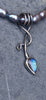 an oxidised silver tendril pendant wraps up and around the black freshwater pearls and down to the bud shaped blue flash labradorite.
on a slate background.