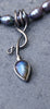 an oxidised silver tendril pendant wraps up and around the black freshwater pearls and down to the bud shaped blue flash labradorite.
on a slate background