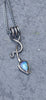 an oxidised silver tendril pendant wraps up and around the oxidised silver spiga chain and down to the bud shaped blue flash labradorite.
on a slate background.