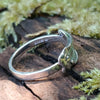Slim Sterling silver melt top ring sits on a mossy log in th e sunshine.