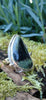 Sterling silver ring with a large green freeform oval Nebula Jasper stone surrounded with tendrils. The ring sits on a mossy log.