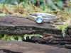 Slim moonstone stacking ringsitting on a mossy log 