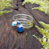 Sterling silver Blue stones stacking ring set. Blue Onyx, Amazonite, blue onyx. Sitting on a mossy log in the sunshine