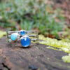 Sterling silver Blue stones stacking ring set. Blue Onyx, Amazonite, blue onyx. Sitting on a mossy log in the sunshine.