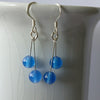 Pair of silver and blue onyx bead double drop earrings silver hooks on a white surface