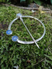 Traditional Silver brooch, penannular pin, ring pin with blue stones on a mossy log.