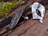 large molten textured Femscape stud earrings sitting on a mossy log in the sunshine.