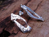 large molten textured Femscape stud earrings sitting on a mossy log in the sunshine.