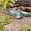 sterling silver 4mm light Moss agate stacking ring on a mossy log