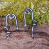 oxidised black Sterling silver twisted tendril studs sit on a mossy log