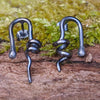 oxidised black Sterling silver twisted tendril studs sit on a mossy log