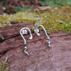 Sterling silver twisted tendril studs sit on a mossy log