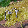 oxidised black Sterling silver twisted tendril studs sit on a mossy log