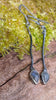 a pair of oxidised silver dangly earrings with bud shaped blue flash labradorite on a mossy log