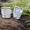 square ish odd melt studs 2 sitting on a mossy log