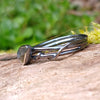 oxidised sterling silver twisted tendril bud ring with blue flash labradorite on a mossy log.