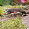 Sterling silver and Garnet  tiny stacking ring on a mossy log