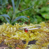 Sterling silver and Garnet  tiny stacking ring on a mossy log