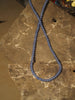 a necklace made of blue onyx beads on a slate background
